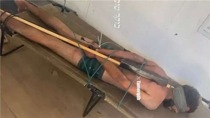 صورة تُظهر أسيرًا عارٍ مكبلًا